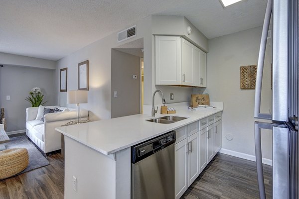Kitchen featuring modern appliances and granite countertops in La Morada at Weston Apartments
