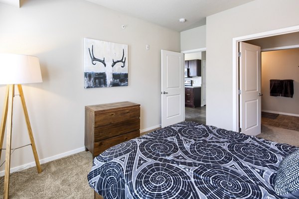Cozy bedroom with modern decor at Grain Belt Apartments, featuring large windows and ample natural light