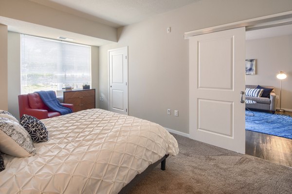 Modern bedroom with plush bedding and contemporary decor at Grain Belt Apartments