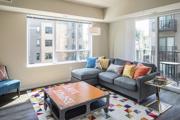 Spacious living room with modern furnishings and large windows in Grain Belt Apartments