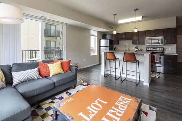 Bright living room with contemporary decor and large windows in Grain Belt Apartments offering luxurious living