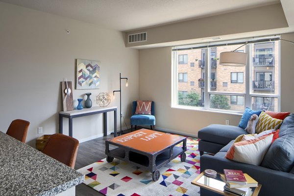 Open-concept living room with modern decor at Grain Belt Apartments, featuring comfortable seating and abundant natural light