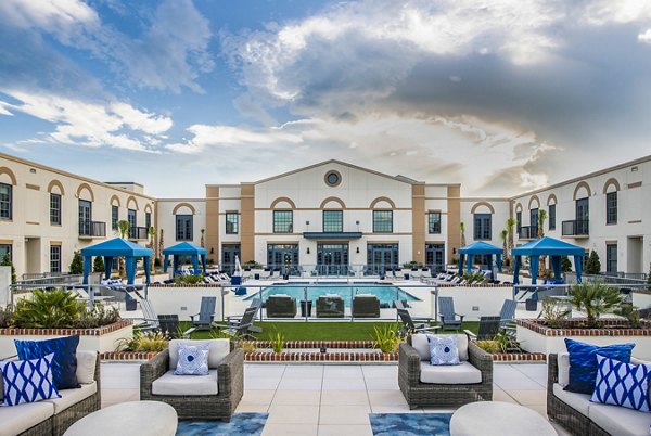 Resort-style pool with lounging area at The Guild Apartments