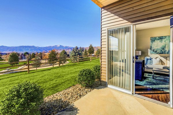 Commons at Briargate Apartments: Cozy patio with comfortable seating and lush greenery