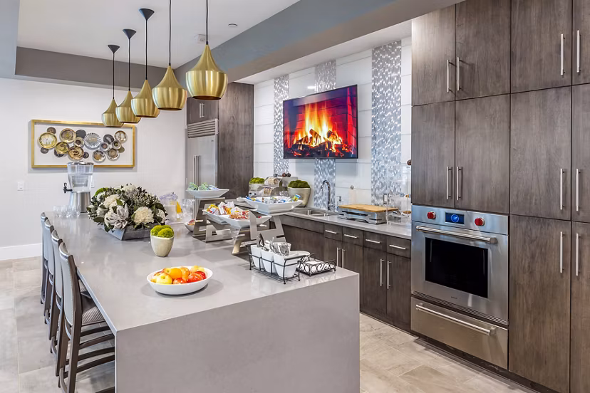 Oversized island and stainless-steel appliances in the clubhouse kitchen at Overture Providence Apartments, a Greystar luxury community
