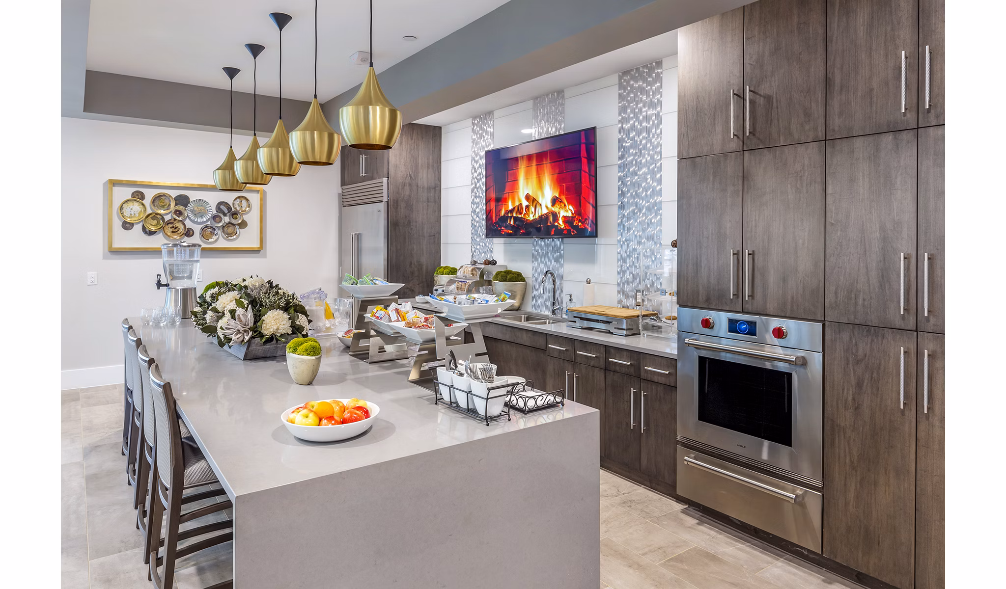 Oversized island and stainless-steel appliances in the clubhouse kitchen at Overture Providence Apartments, a Greystar luxury community