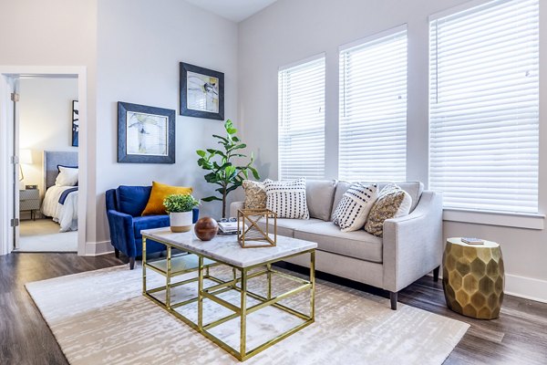 Modern living room with plush seating and ample natural light at Overture Providence Apartments, a Greystar luxury apartment community