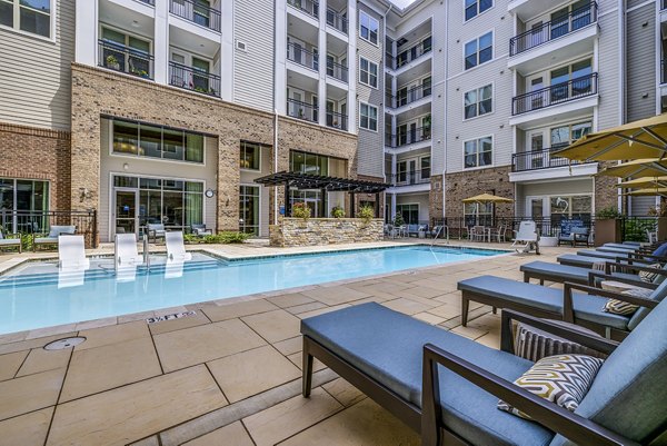 Serene outdoor pool with lounge chairs at Overture Providence Apartments, perfect for relaxation and enjoying the sun