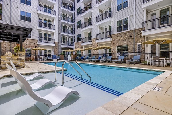 Sunlit outdoor pool at Overture Providence Apartments, offering luxury relaxation and wellness amenities