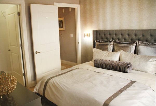 The Harper at Harmon Meadow Apartments: Cozy bedroom with modern furnishings