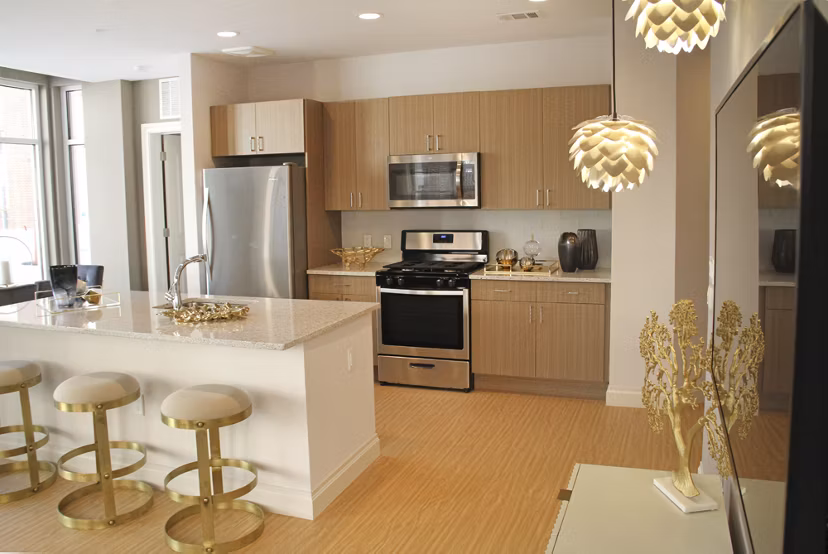 Spacious kitchen with modern appliances and breakfast bar at The Harper at Harmon Meadow Apartments
