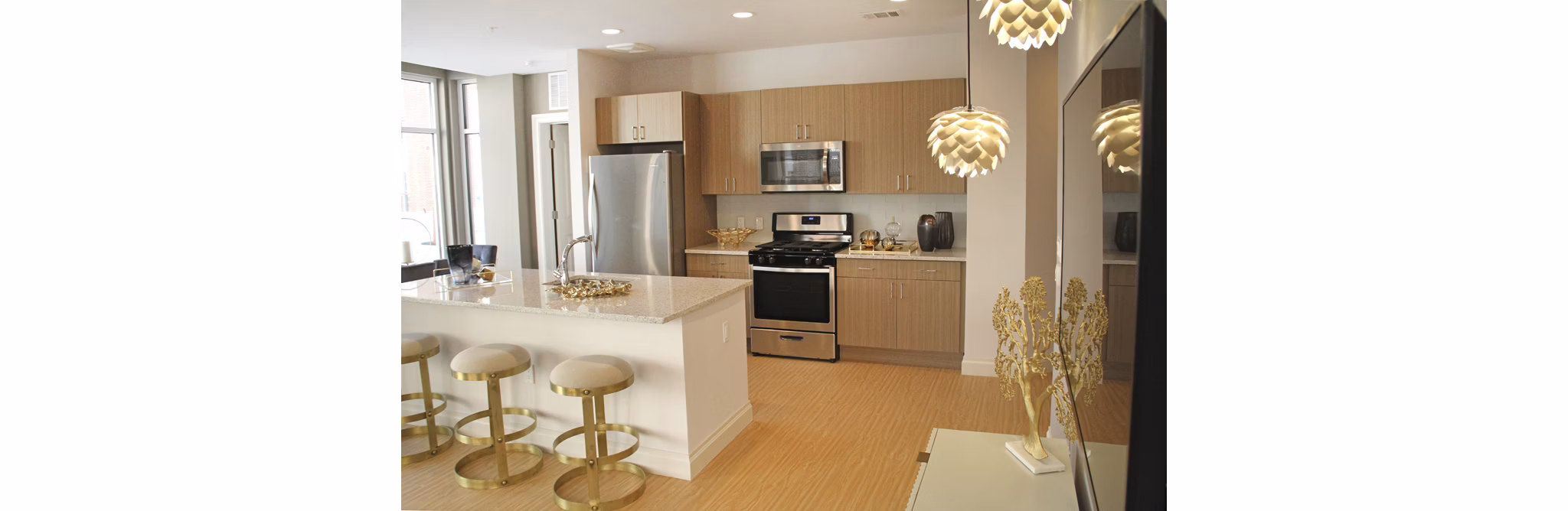 Spacious kitchen with modern appliances and breakfast bar at The Harper at Harmon Meadow Apartments