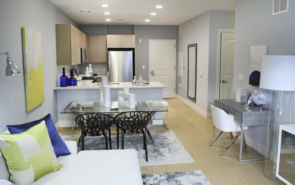 The Harper at Harmon Meadow: Contemporary living room with designer furnishings and ample natural light, ideal for luxury apartment living