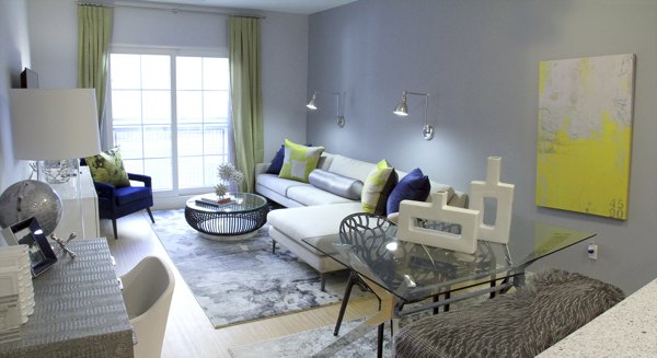 Living room with modern decor and large windows at The Harper at Harmon Meadow Apartments, luxury living by Greystar in New Jersey