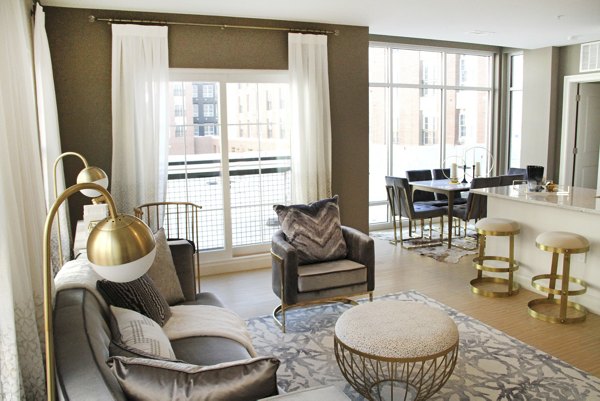 Spacious living room with modern decor and large windows at The Harper at Harmon Meadow Apartments