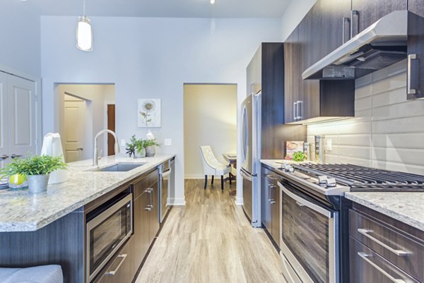 Modern kitchen with stainless steel appliances at Overture Yorktown Apartments offering luxury living for senior residents