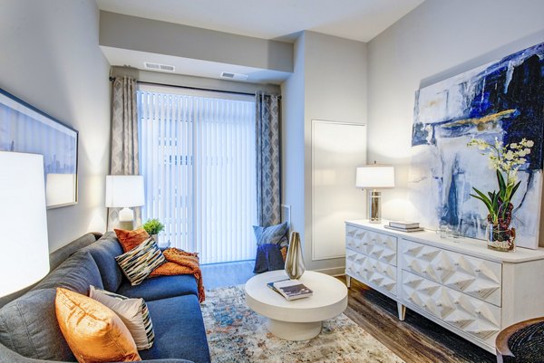 Living room featuring modern decor and large windows at Overture Yorktown Apartments, a luxury community offering stylish interiors
