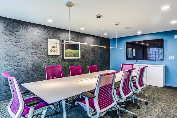 Modern meeting facility equipped with conference table and chairs at Zinc Apartments, ideal for collaborative work sessions and events