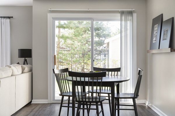 Dining room featuring elegant decor with large dining table and modern lighting at Pembroke Woods Apartments, luxury living in serene surroundings