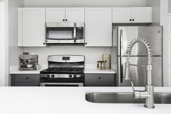 Modern kitchen featuring stainless steel appliances and granite countertops at Pembroke Woods Apartments