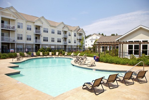 Outdoor pool area with sun loungers at Pembroke Woods Apartments enhances relaxation and leisure