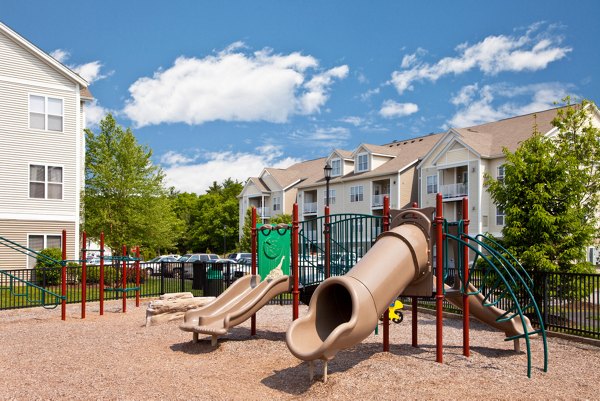 Children playing on modern playground at Pembroke Woods Apartments, a luxury community offering family-friendly amenities in a serene setting
