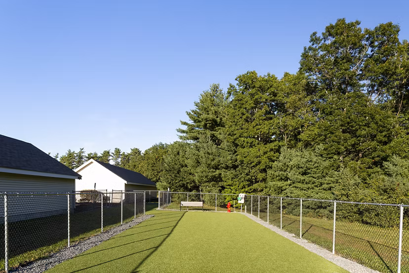 Dog park with play area and benches at Pembroke Woods Apartments, a pet-friendly luxury community offering outdoor activities