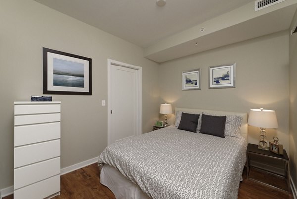 The Aspen Apartments: Luxurious bedroom with modern decor and ample natural light