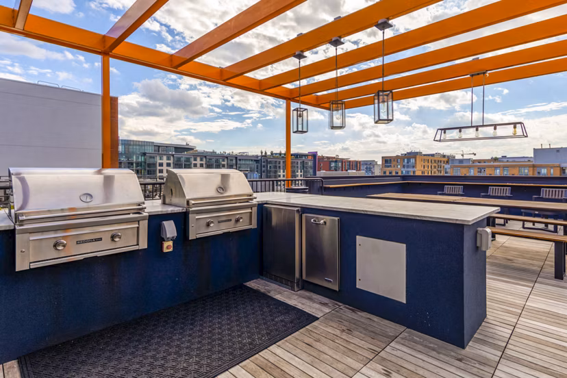 Grill area with shaded seating at The Aspen Apartments, luxury living with outdoor amenities