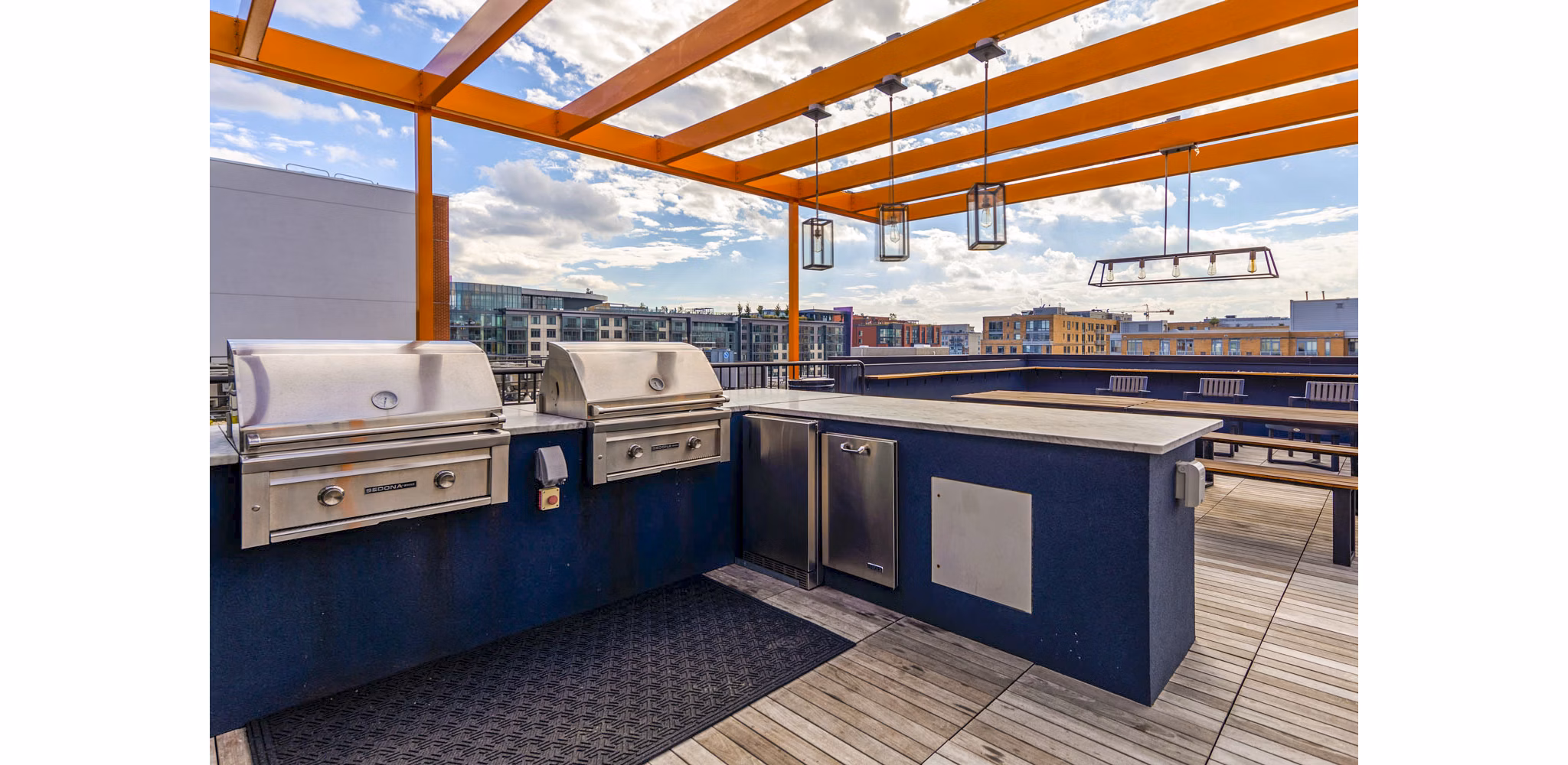 Grill area with shaded seating at The Aspen Apartments, luxury living with outdoor amenities