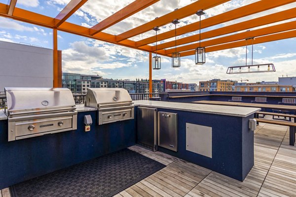 Grill area with shaded seating at The Aspen Apartments, luxury living with outdoor amenities