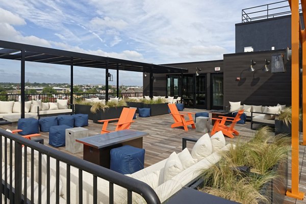 Rooftop patio with seating and greenery at The Aspen Apartments