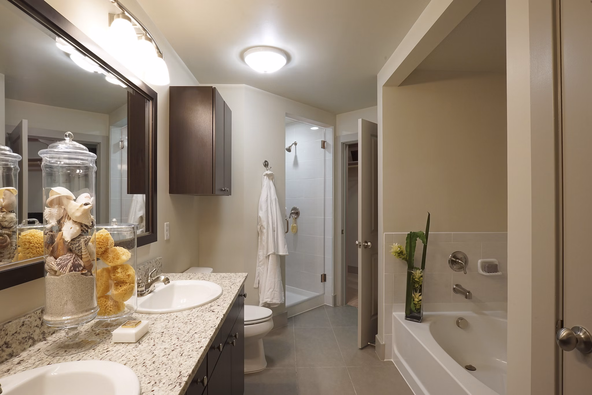 Modern bathroom featuring a double sink vanity, bathtub, and shower in luxury apartment