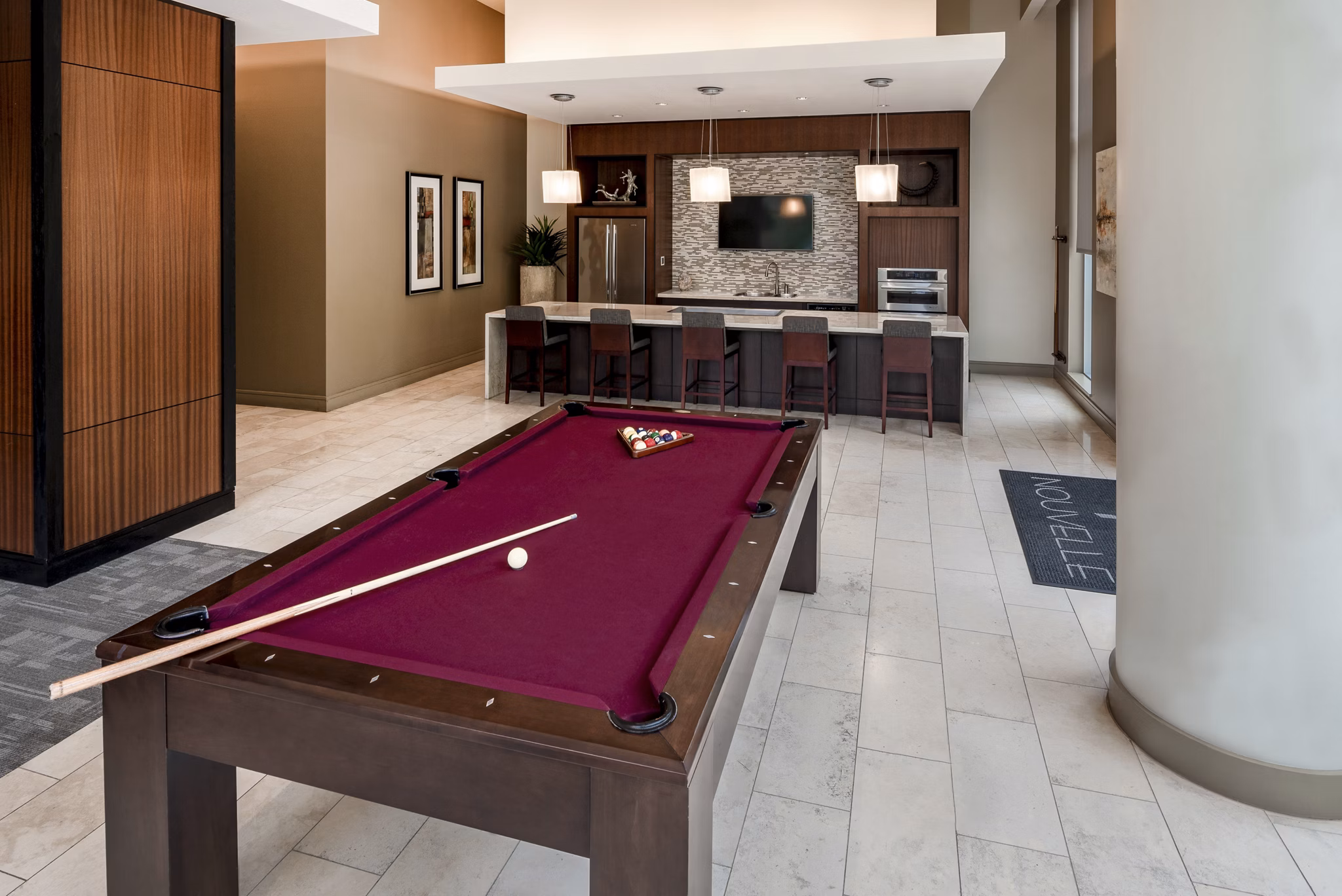 Modern lounge area with a pool table and bar seating at luxury apartments