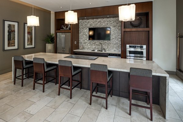 Modern kitchen featuring large island and bar stools with pendant lights and built-in appliances