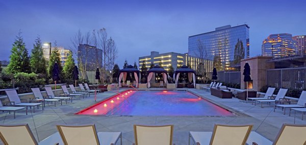 Luxury outdoor swimming pool area with lounge chairs and cabanas at Greystar luxury apartments