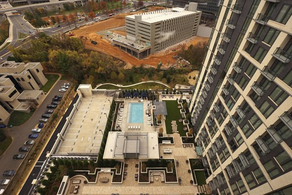Luxury high-rise apartments with a swimming pool and patio area in an urban setting