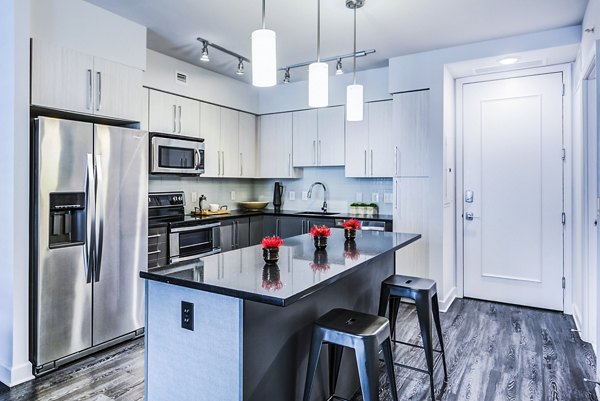 Modern kitchen with granite countertops and stainless steel appliances at Latitude Apartments Luxury living with top-notch amenities