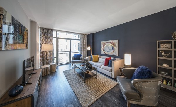 Expansive living room with modern furnishings and natural light at Latitude Apartments