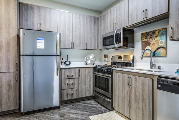 Modern kitchen with stainless steel appliances in Acacia on Santa Rosa Creek Apartments