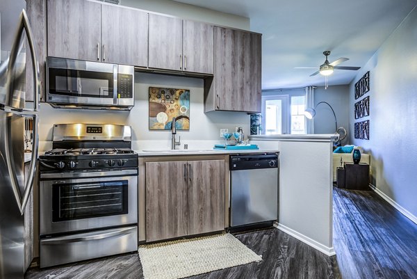 Modern kitchen with stainless steel appliances at Acacia on Santa Rosa Creek Apartments