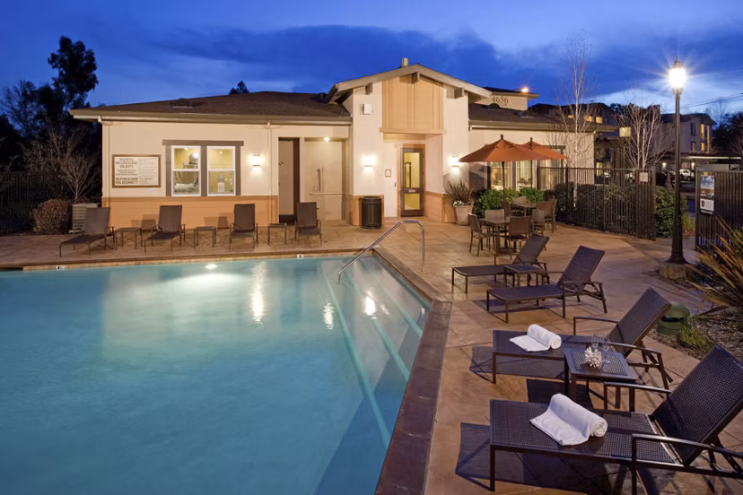 Resort-style pool with lounge chairs at Acacia on Santa Rosa Creek Apartments