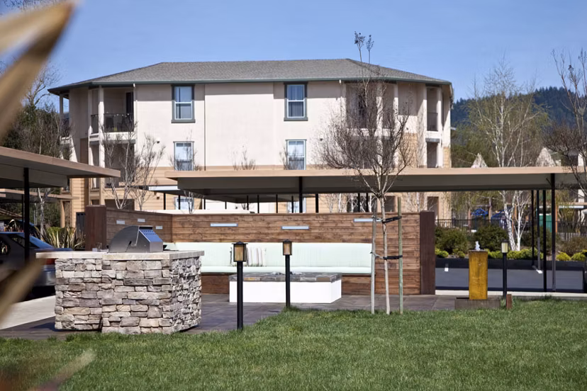 Grill station with modern BBQ facilities at Acacia on Santa Rosa Creek Apartments in a landscaped outdoor setting