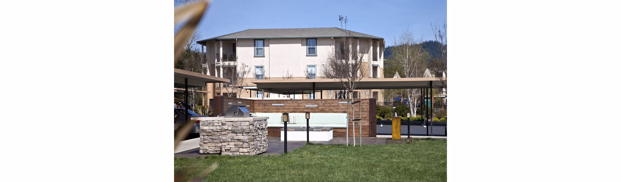 Grill station with modern BBQ facilities at Acacia on Santa Rosa Creek Apartments in a landscaped outdoor setting