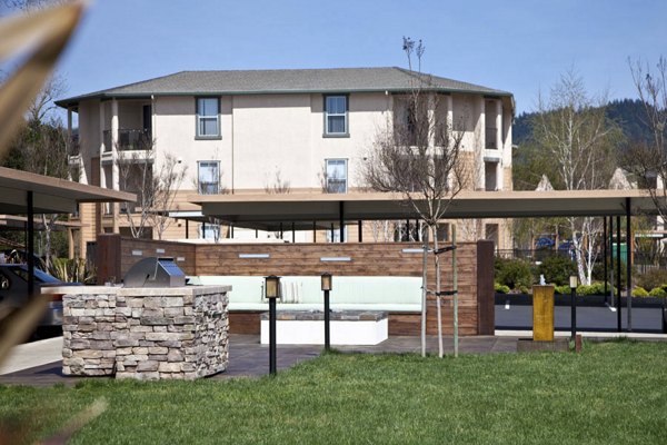 Grill station with modern BBQ facilities at Acacia on Santa Rosa Creek Apartments in a landscaped outdoor setting
