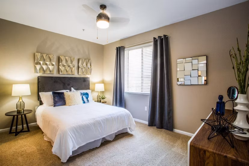 Contemporary bedroom featuring sleek decor and a city view at Glo Las Vegas Apartments, embodying luxury living