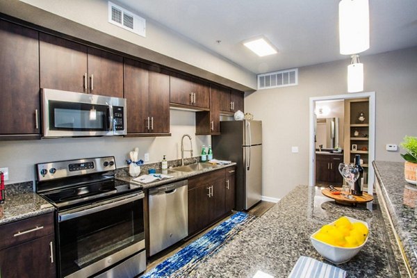 Modern kitchen with sleek appliances and island seating at Glo Las Vegas Apartments, perfect for luxury living