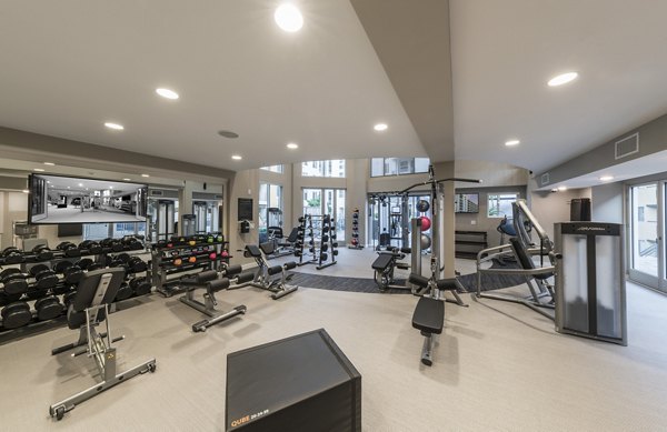 State-of-the-art fitness center at The Desmond Apartments featuring cardio machines and free weights for residents