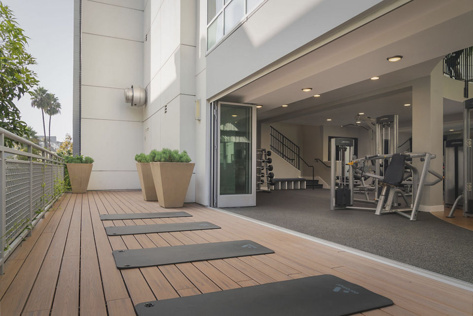State-of-the-art fitness center at The Desmond Apartments featuring cardio machines and free weights for residents