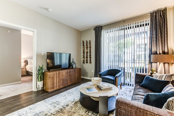 Modern living room with contemporary decor at The Gallery at NoHo Commons Apartments, featuring plush seating and expansive natural light